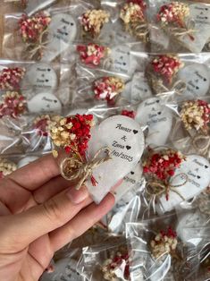 someone is holding some heart shaped cookies with flowers on them in plastic wrapper bags