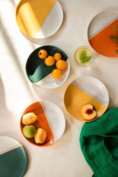 four plates with fruit on them sitting on a table