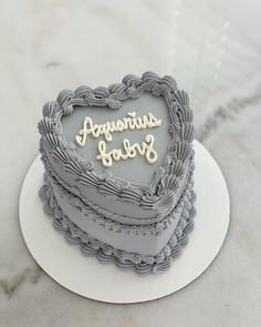 a heart shaped cake sitting on top of a white plate next to a marble counter