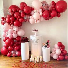 a bunch of balloons and candles on a table with confetti in the middle