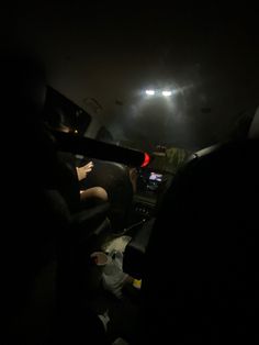 the interior of a car at night with lights on and people sitting in the passenger seat