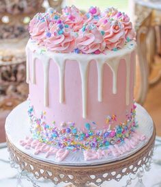 a pink cake with sprinkles and frosting