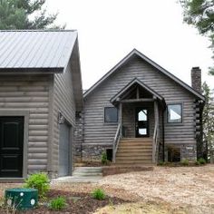 a log cabin sits in the middle of a wooded area with stairs leading up to it