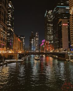 a boat traveling down a river next to tall buildings