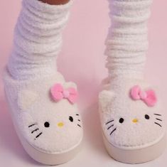 a close up of a person's feet wearing hello kitty slippers and socks