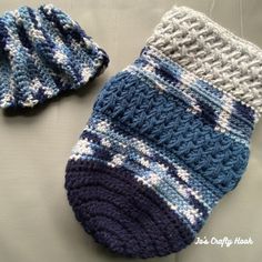 two crocheted mittens and a hat are laying on a table top together