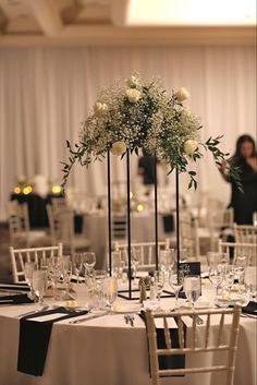 the tables are set with white flowers and place settings for guests to sit down at