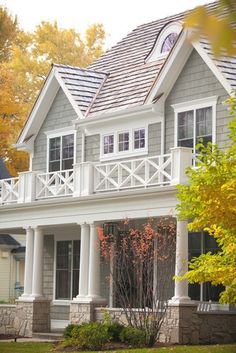 a large gray house with white trim and windows