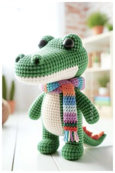 a crocheted stuffed alligator with a scarf around its neck