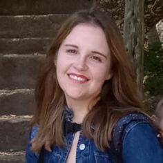 a woman holding a baby in her arms on the steps with stairs behind her smiling