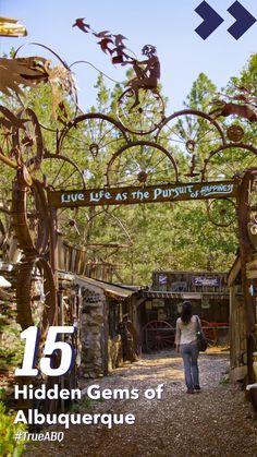 a woman walking down a dirt road under a canopy covered in vines and branches with the words hidden gems of albuqueraque