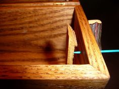 an open wooden box sitting on top of a black table next to a blue object