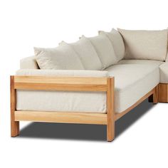 a white couch with wooden frame and pillows