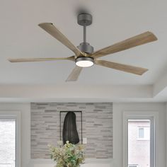 a living room with white couches and a ceiling fan