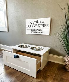 a dog house with two bowls on the floor and a sign that says doggy diner