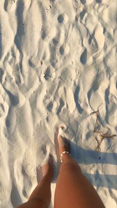 the person is standing in the snow with their feet up and her leg on the ground