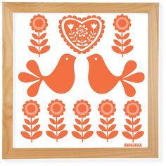 two birds sitting on top of flowers in front of a heart shaped wall art frame