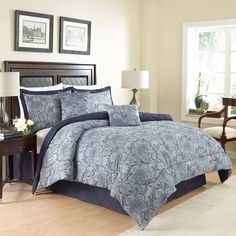 a bed with blue and white comforters in a bedroom