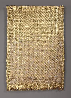 a piece of gold cloth with small squares on the bottom and sides, hanging from a wall