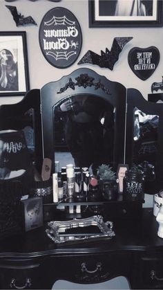 a black dresser topped with lots of halloween decorations and decorating items on top of it