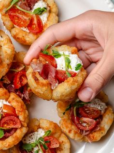 small appetizers with tomatoes, cheese and herbs are on a white platter