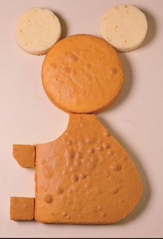 a piece of cheese shaped like a mouse with ears on it's head and two pieces of bread in the shape of a mouse