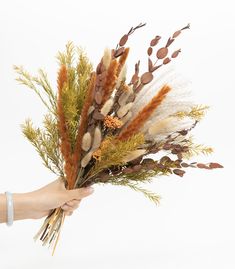 a person is holding some dried flowers in their hand