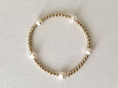 "* HANDMADE ITEM * DIMENSIONS:  - Fresh Water pearls: 5 mm  - 14K Gold Filled  beads: 3 mm - Bracelet size: 6\", 6.5\", 7\", 7.5\", 8\"  * MATERIALS:  - Natural White Fresh Water pearls - 14K Gold Filled beads The featured elastic bracelet is made of natural white Fresh Water Pearl with 14K Gold Filled beads.  Please select desired bracelet size  from drop down menu. * GIFT READY: Comes in a neat gift box * SHIPPING: - Ships out from California via USPS First-Class  in 1-3 Business Days - You can select different shipping options at checkout * Packaged in a neat gift box. ** Please note that the deco ribbon shown on the gift box photo does not come with a package. Demonstration purposes only. * CARE PRACTICES: Keep your bracelet away from natural sunlight and heat, polish it regularly with Classic White Pearl Bracelet With Gold Beads, Classic White Beaded Stretch Bracelet, Classic White Beaded Bracelets With Gold Beads, Adjustable Gold Bracelet With Pearl Round Beads, Gift Box Photo, Bracelet For Girls, Box Photo, Stackable Bracelets, Fresh Water Pearl