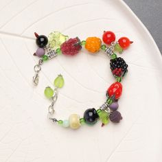 "This cute and playful berry bracelet is perfect for any fruit lover. The glass fruit beads are crafted with great attention to detail, creating a unique and colorful accessory. This kawaii charm bracelet is a great addition to any jewelry collection and makes a wonderful gift for any occasion. It's a must-have for those who love fun and whimsical jewelry. 💕 You will definitely look stunning with this glass fruit bracelet! 👉 This bracelet is adjustable and fits a 16-17.5cm (6 1/4\"- 7\" inch) Playful Jewelry With Fruit Design For Gift, Playful Fruit Design Jewelry For Gifts, Adjustable Beaded Bracelets With Fruit Design As Gift, Adjustable Beaded Bracelet With Fruit Design As Gift, Cute Berry Colored Jewelry With Fruit Design, Cute Berry-colored Jewelry With Fruit Design, Cute Berry-colored Fruit Design Jewelry, Adjustable Fun Fruit Design Jewelry, Cute Multicolor Fruit Design Jewelry