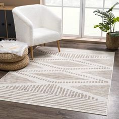 a living room area with a chair, rug and potted plant