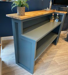 a blue counter top sitting next to a potted plant on a wooden table in a room