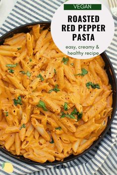 a pan filled with red pepper pasta on top of a striped cloth next to a fork and knife