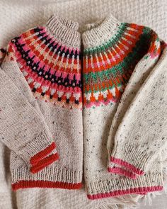 two knitted sweaters laying on top of each other