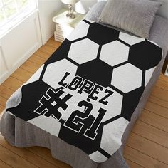 a black and white soccer ball quilt on a bed in a room with hardwood floors