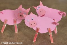 three pink pigs are standing on sticks with their backs turned to look like they're cut out of paper