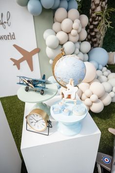 a table topped with lots of different types of toys and balloons in the shape of airplanes