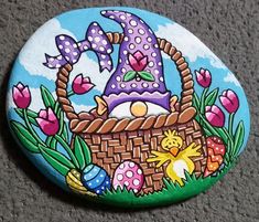 a painted rock with an easter basket on it