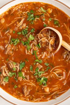 a bowl of soup with noodles, meat and parsley