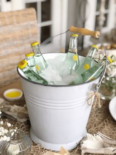 a bucket filled with ice and bottles on top of a table