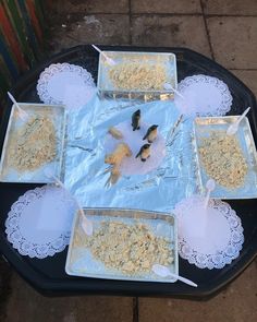 several trays filled with food sitting on top of a table