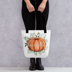 a woman wearing black boots holding a white bag with a pumpkin on it and the words happy thanksgiving