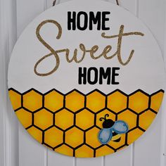 a sign that says home sweet home with a bee on the front and honeycombs on the back