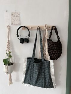 three purses hanging up on a wall with hooks and earphones attached to them