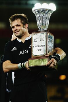 a man holding up a trophy in front of him