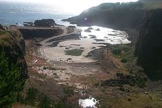 an aerial view of the beach and ocean from above, with sun shining on the water