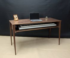 a computer desk with a laptop and keyboard on it