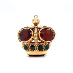 Make your yellow gold chain stand out with this Mid-Century crown pendant in 18 karat yellow gold! Five (5) 4.50 carat amber-hued citrine gems and four (4) seed pearls decorate the top of the crown. Ten (10) tsavorite garnets, each with a blue-green hue, are bezel set around the base of the crown. Starburst engravings and a decorative bail in 18K yellow gold add texture and dimension to this opulent crown pendant. A sweet gift idea for any Mid-Century jewelry lover! Composition: 18 Karat Yellow Luxury Gold Crown Jewelry, Luxury Yellow Gold Crown Jewelry, Luxury Yellow Gold Crown-shaped Jewelry, Luxury Amber Jewelry For Formal Occasions, Luxury Jeweled Yellow Gold Jewelry, Luxury Crown Design Jewelry For Formal Occasions, Formal Yellow Gold Crown Jewelry, Luxury 14k Gold Amber Jewelry, Luxury Yellow Gold Jeweled Necklace