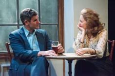 a man and woman sitting at a table talking