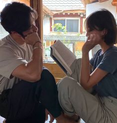 two people sitting on the floor reading books