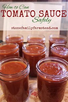 several jars filled with tomato sauce sitting on top of a table